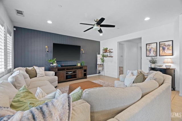 living area with recessed lighting, a ceiling fan, light tile patterned flooring, and an accent wall