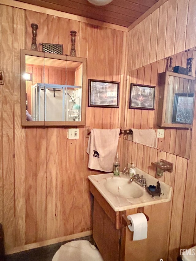 bathroom with wood walls, sink, and wooden ceiling