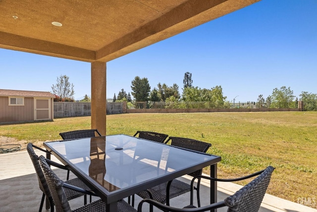 view of patio / terrace featuring an outdoor structure, outdoor dining area, and fence