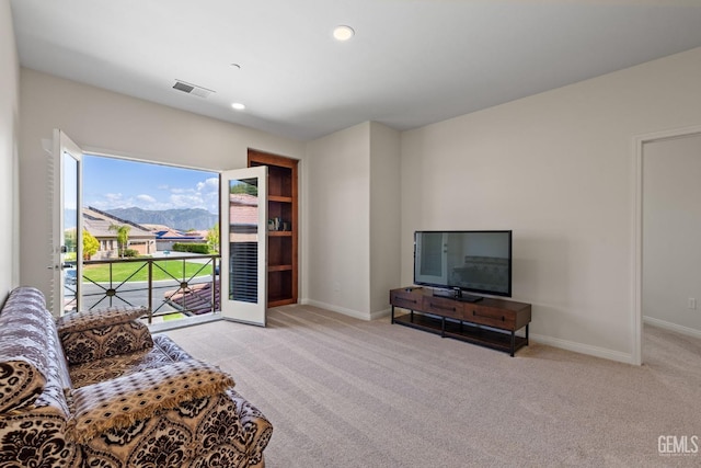 living room with recessed lighting, light carpet, visible vents, and baseboards