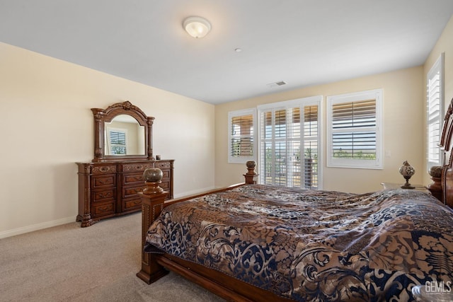 bedroom with visible vents, light carpet, baseboards, and multiple windows