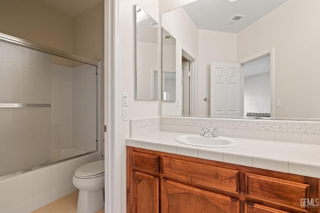 full bathroom with toilet, visible vents, tile patterned flooring, combined bath / shower with glass door, and vanity