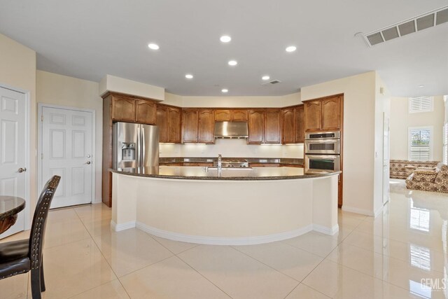 kitchen with visible vents, appliances with stainless steel finishes, baseboards, and under cabinet range hood