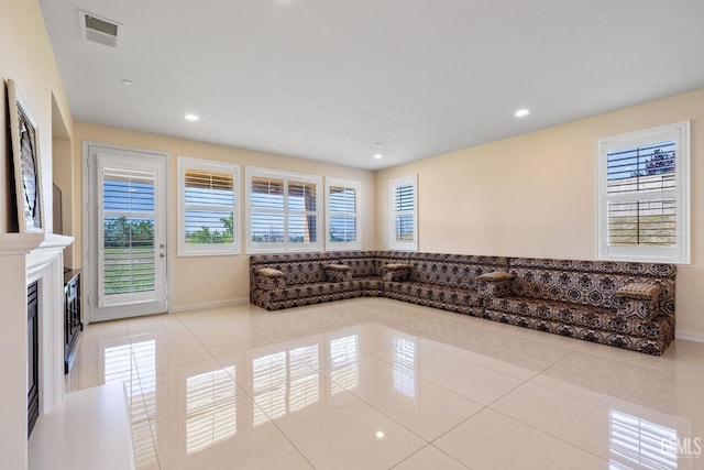 tiled living room featuring baseboards, visible vents, and recessed lighting