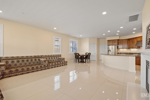 living room featuring light tile patterned flooring, visible vents, and recessed lighting