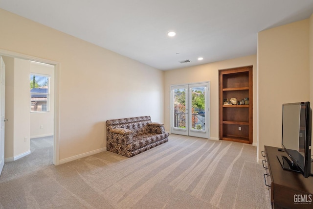 living area with light carpet, baseboards, visible vents, recessed lighting, and built in features