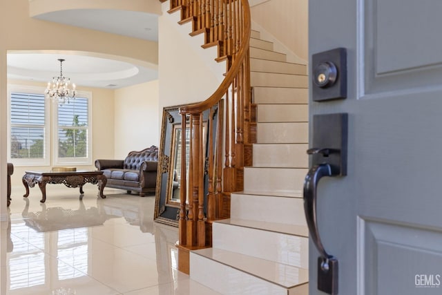 stairs featuring arched walkways, a chandelier, and tile patterned floors