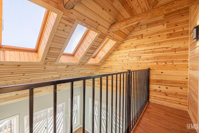 bonus room featuring hardwood / wood-style floors, lofted ceiling with skylight, wooden walls, and wood ceiling