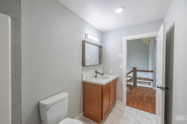 bathroom featuring vanity, a textured ceiling, and toilet