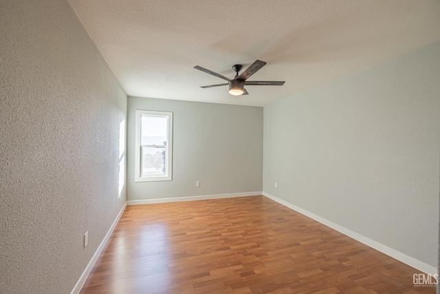 empty room with hardwood / wood-style floors, ceiling fan, and a textured ceiling