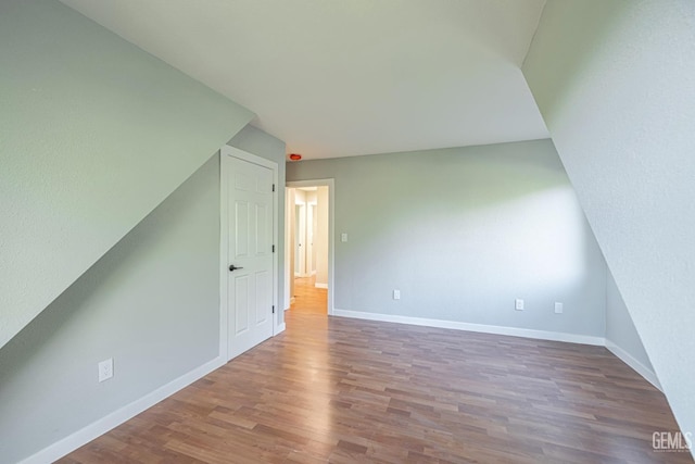 bonus room with hardwood / wood-style floors and lofted ceiling