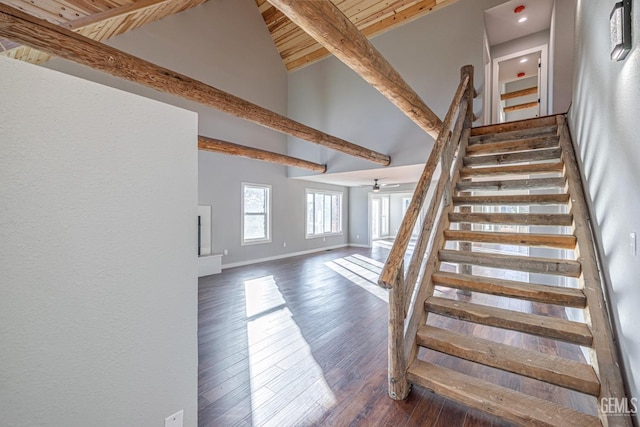 stairway with ceiling fan, wooden ceiling, beamed ceiling, high vaulted ceiling, and wood-type flooring