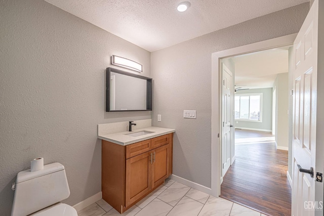 bathroom featuring vanity, toilet, and a textured ceiling