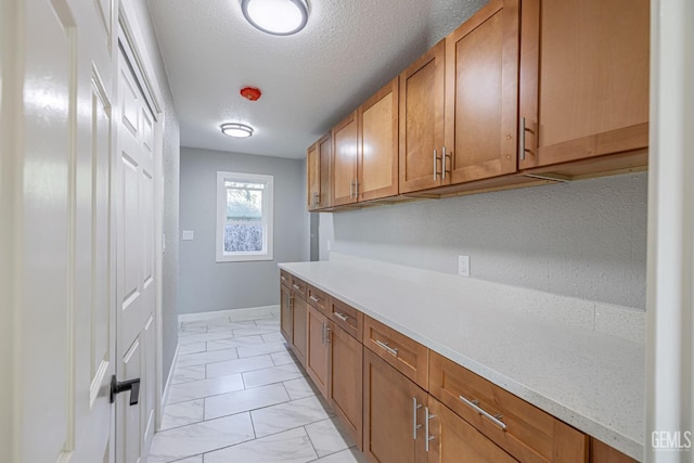 kitchen with light stone countertops and a textured ceiling