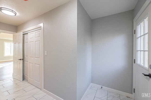 hall featuring a textured ceiling