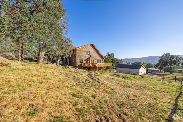 view of yard with a deck with mountain view