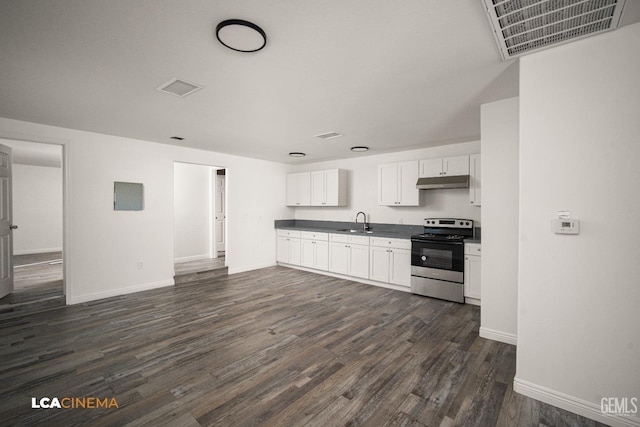 kitchen with under cabinet range hood, visible vents, white cabinetry, dark countertops, and stainless steel range with electric stovetop