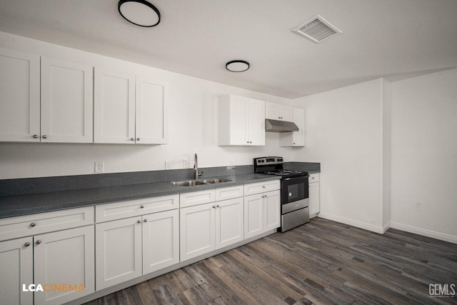 kitchen with stainless steel range with electric stovetop, dark countertops, a sink, and under cabinet range hood