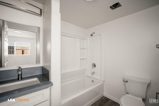 full bath featuring baseboards, toilet, wood finished floors, vanity, and shower / bathing tub combination