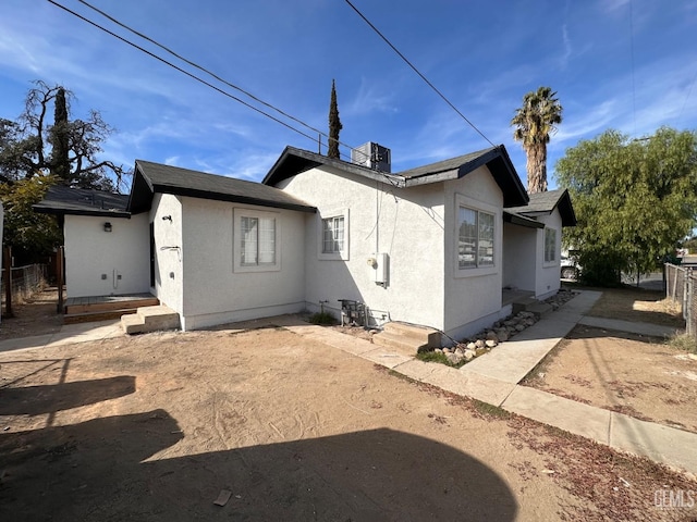 back of house with fence and stucco siding