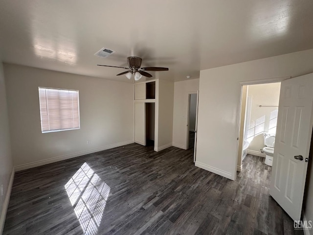 unfurnished bedroom with a closet, dark wood-style flooring, visible vents, and baseboards