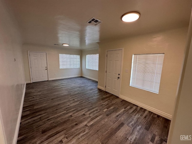 foyer with baseboards, visible vents, and dark wood finished floors