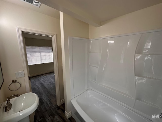 bathroom with wood finished floors, a sink, visible vents, and shower / bathing tub combination