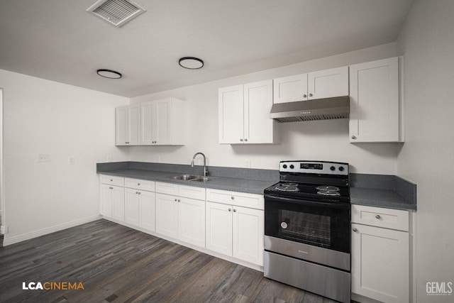 kitchen with stainless steel range with electric stovetop, dark countertops, white cabinets, and under cabinet range hood