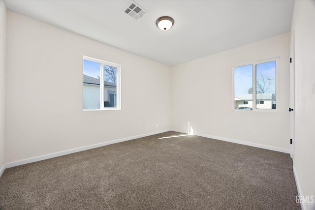 unfurnished room featuring dark colored carpet