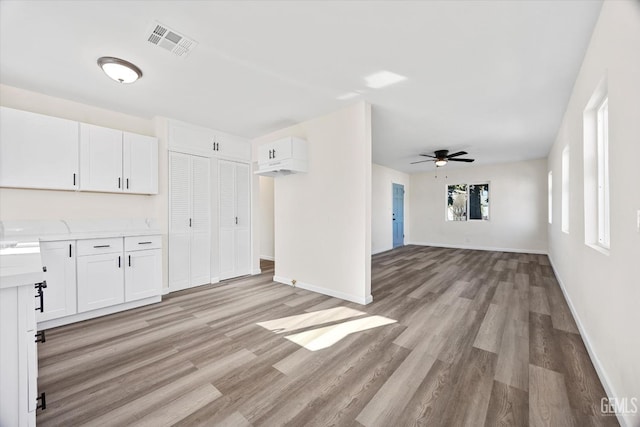 unfurnished living room featuring ceiling fan and light hardwood / wood-style flooring