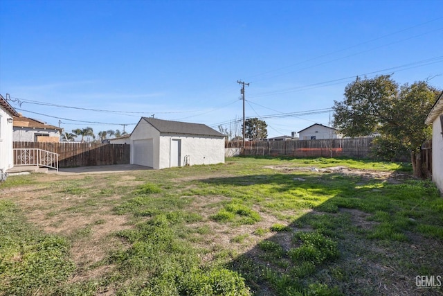 view of yard with a garage and an outbuilding