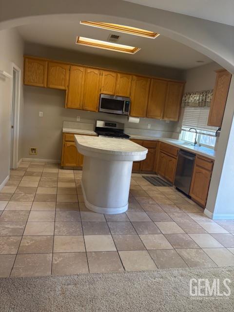 12006 Roaring River Ave, Bakersfield, CA 93311 - kitchen with stainless steel appliances, light countertops, and light tile patterned floors
