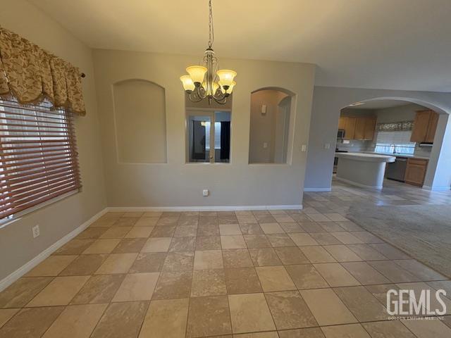 12006 Roaring River Ave, Bakersfield, CA 93311 - unfurnished dining area featuring a chandelier and arched walkways