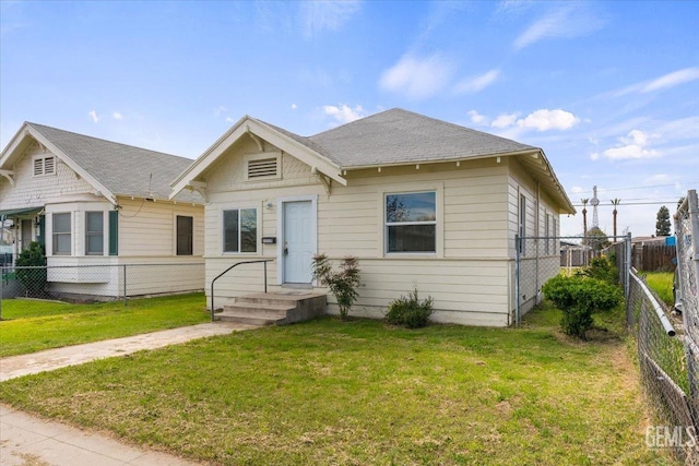 bungalow-style house with a front lawn, fence, and roof with shingles