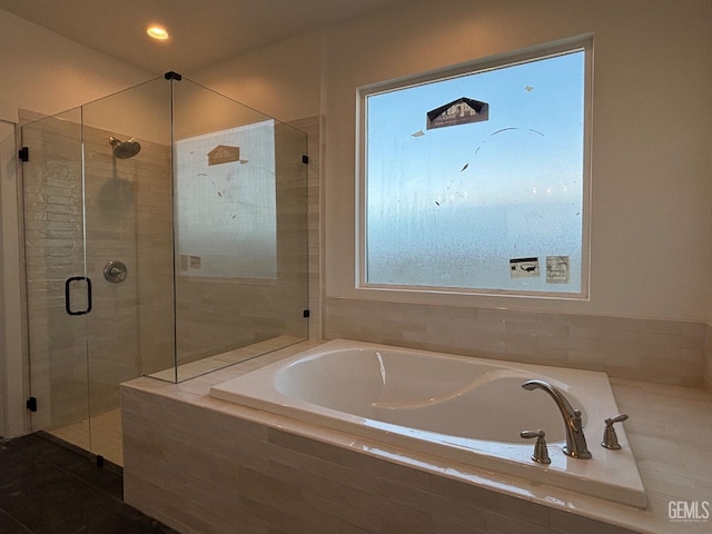 bathroom featuring a garden tub and a shower stall