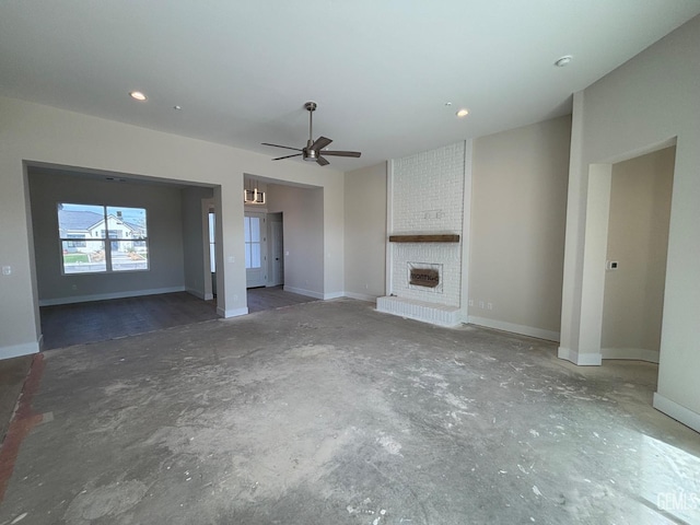 unfurnished living room featuring ceiling fan and a brick fireplace