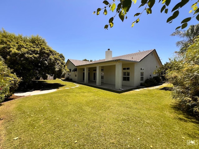 4812 Prairie Meadows Way, Bakersfield, CA 93312 - rear view of house featuring a chimney, a yard, stucco siding, and a patio area