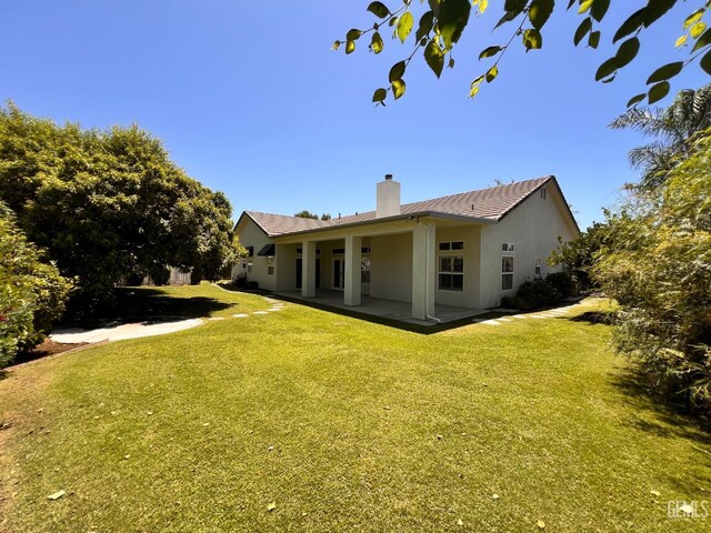 4812 Prairie Meadows Way, Bakersfield, CA 93312 - rear view of house featuring a chimney, a yard, stucco siding, and a patio area