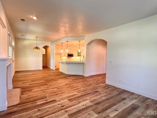 4812 Prairie Meadows Way, Bakersfield, CA 93312 - unfurnished living room with arched walkways and light wood-type flooring