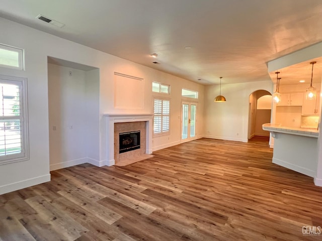 4812 Prairie Meadows Way, Bakersfield, CA 93312 - unfurnished living room with arched walkways, wood finished floors, and a tiled fireplace