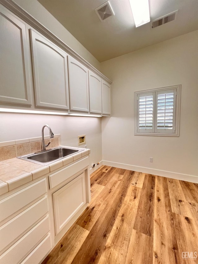 4812 Prairie Meadows Way, Bakersfield, CA 93312 - washroom with hookup for a washing machine, cabinet space, and light wood-style floors