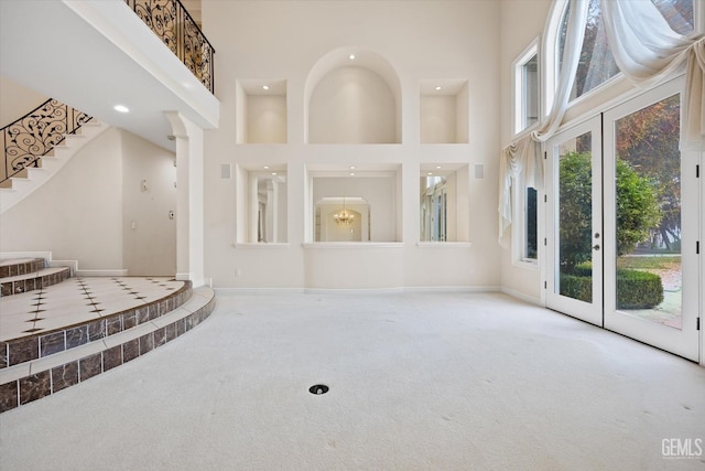 entrance foyer with carpet flooring and a high ceiling