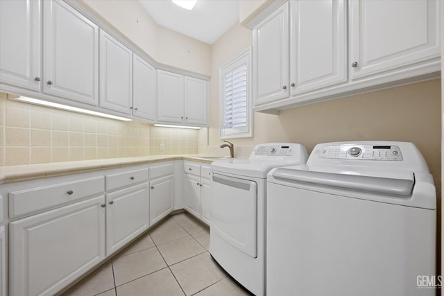 laundry area with separate washer and dryer, sink, light tile patterned floors, and cabinets