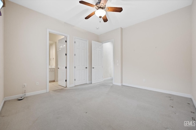 unfurnished bedroom with ensuite bathroom, ceiling fan, and light colored carpet