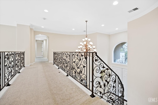 corridor featuring light carpet, an inviting chandelier, and crown molding