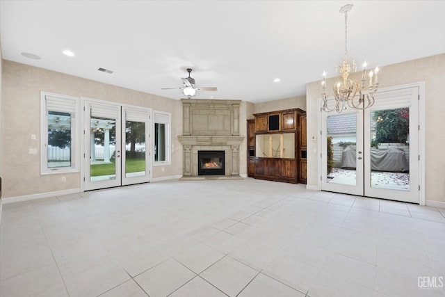 unfurnished living room featuring a fireplace, light tile patterned flooring, and ceiling fan with notable chandelier