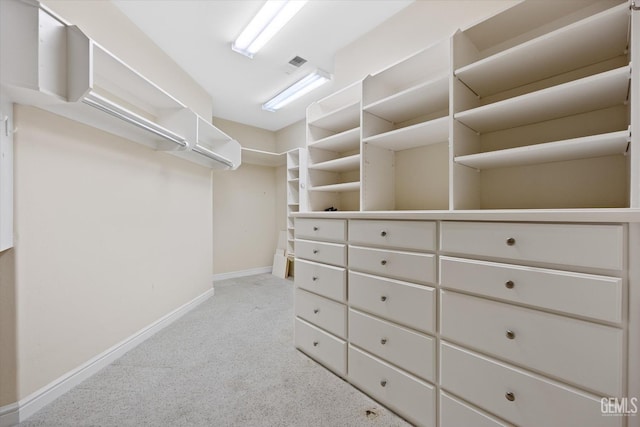 walk in closet with light colored carpet