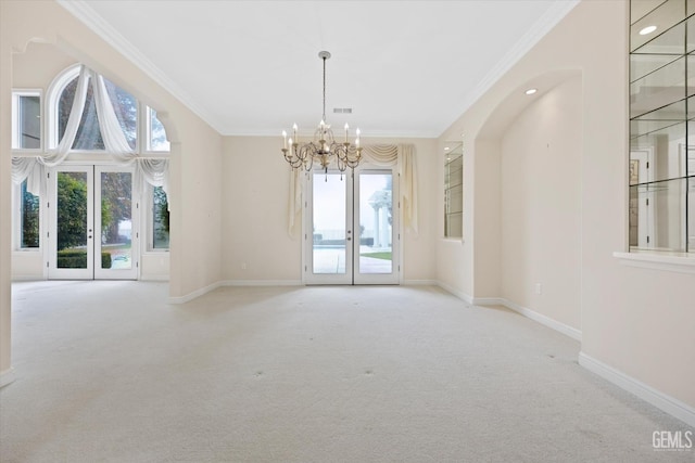 empty room with light carpet, french doors, a notable chandelier, and ornamental molding