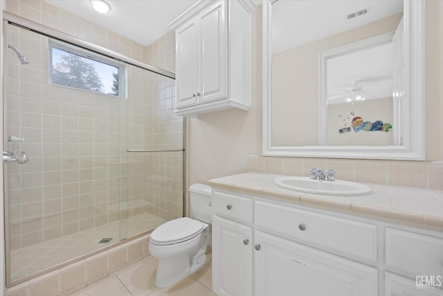 bathroom featuring vanity, tile patterned flooring, ceiling fan, toilet, and a shower with shower door