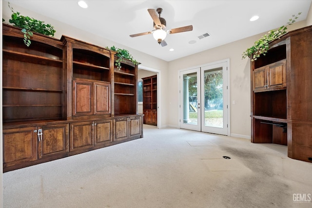 unfurnished living room with light carpet, french doors, and ceiling fan